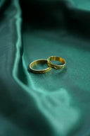 Two gold wedding bands in 18k gold featuring smooth and intricate textured designs perfect for fine jewelry weddings