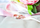 A rose gold engagement ring with central diamond and pavé detailing paired with a silver band in fine jewelry