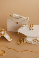 a white box with gold jewelry on it