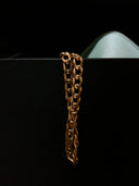 a close up of a gold chain on a black surface