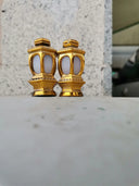 a pair of gold - plated candlesticks sitting on a table