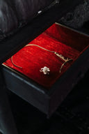 A delicate gold-toned floral necklace on red velvet in an elegant box featured by everett jewelry store