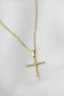 A gold cross necklace on a white mannequin