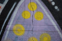 Graffiti art with purple and yellow circles on wall.