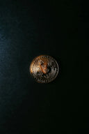 a bitcoin sitting on top of a black surface