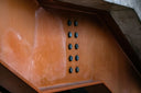 Rusty orange steel beam with black bolts in crown jewels exhibit