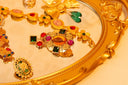 A golden ornate brooch with amber gem and vibrant stones showcasing fine art gold jewelry in lost royal jewels history.