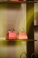 Two pink leather handbags with gold-tone hardware showcased at everett jewelry store highlighting innovative craftsmanship.