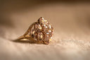 A delicate gold engagement ring with oval-cut pink gemstones and a braided design in fine gold jewelry style.