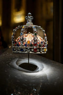 A regal art gold crown adorned with multicolored gemstones and intricate silver filigree from cleopatras fine jewelry collection