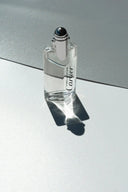 A sleek transparent glass bottle of cartier decouration perfume with a silver cap enhancing art gold jewelry insights