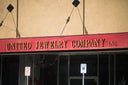 Red sign with gold lettering for united jewelry company inc highlighting fine jewelry and 18k gold investments.