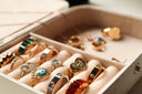 A collection of gold-toned engagement rings and wedding bands with emerald, ruby stones, and heart charms from Everett jewelry store.