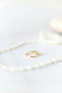 A delicate 18k gold wedding band with a single diamond, showcasing fine gold jewelry in Everett Massachusetts.