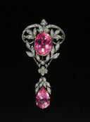An elegant silver brooch with a large oval pink gemstone and diamond leaf settings inspired by gemstone legends.