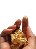 Hands holding crumpled gold leaf from largest gold nugget discovery
