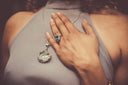 A silver chain necklace with a textured natural stone pendant complements fine jewelry and 18k gold collections.