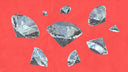 Faceted clear gemstones with reflective surfaces scattered on a red background symbolizing crown jewels in fine jewelry traditions