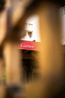 A red cartier awning featuring elegant white cursive lettering complements fine jewelry and 18k gold themes