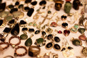 A collection of gold-toned pendants with green and black stones featured at an everett jewelry store showcasing fine craftsmanship.