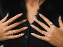 A pair of hands wearing silver band diamond rings showcasing fine jewelry innovations in luxury jewelry design.