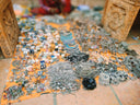 A vibrant orange mat showcasing fine jewelry with silver and black necklaces bracelets and earrings by rinaldo borges