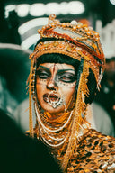A person wearing elaborate gold jewelry with intricate beadwork and face paint featured in art gold jewelry tips for Everett shoppers.