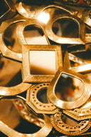 Assortment of golden decorative mirrors in various shapes.