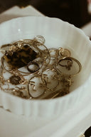 A collection of intricate gold jewelry including 18k gold rings and pendants featuring faces and cacti designs