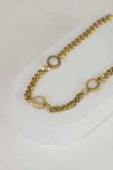 a close up of a gold chain on a white surface