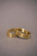 Two interlocking gold rings with polished finish and subtle grooves showcasing fine jewelry and gold jewelry trends.