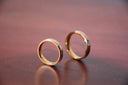 Two gold-toned wedding bands with polished finish and tapered design showcasing fine gold rings in modern gold jewelry collections