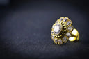 A gold-toned nose ring with a central oval-cut gemstone and floral design featured in wedding bands from everett jewelry store