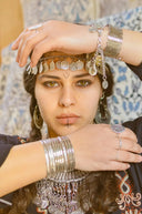 Silver coin headpiece with dangling metallic discs and intricate chain detailing featured in fine jewelry history article.