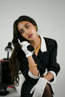 Black pinstripe blazer with white collar and cuffs featured in navigating vintage fine jewelry and gold jewelry insights.