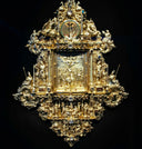 Golden ornate clock with intricate baroque detailing representing royal jewels and 18k gold jewelry heritage