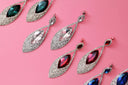 Elegant teardrop-shaped earrings with clear and colored gemstones in silver-toned art gold frame for personalized gold jewelry.