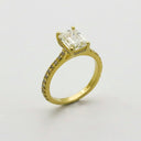 A radiant emerald-cut diamond engagement ring with pavé diamonds on a yellow gold band from everett jewelry store.