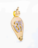 Gold jewelry pendant featuring ornate diamond inlaid om symbol with polished edges in fine art gold jewelry design