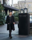 a man walking down a street next to a tall building