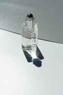 clear glass perfume bottle on black table