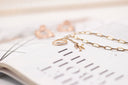 gold necklace on white paper