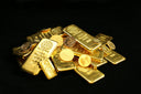 A pile of gold bars and coins on a black background