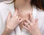 a close up of a person wearing rings and a necklace