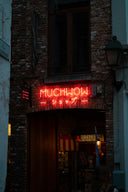 a red neon sign that is on the side of a building