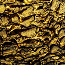 a close up of a textured surface with gold paint