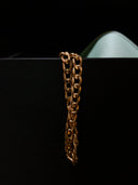 a close up of a gold chain on a black surface