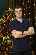 a man standing in front of a christmas tree