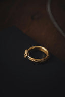 a gold ring sitting on top of a black surface
