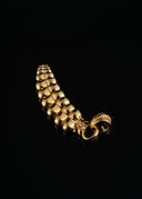a close up of a gold bracelet on a black background